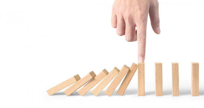 hand-stopping-domino-effect-stopped-by-unique